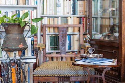 a table and chairs in a library with books at Casa d'artista - Camere in residenza di Charme in Alassio