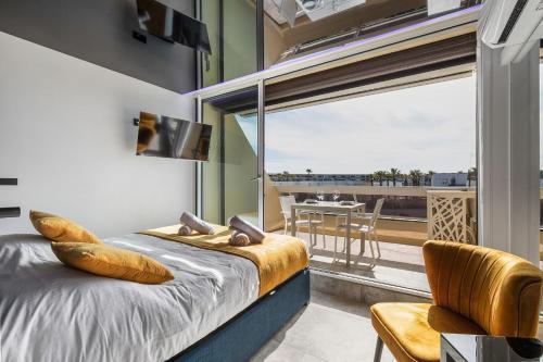 une chambre avec un lit et un balcon avec une table dans l'établissement Village Naturiste R4N- Serenity Heliopolis sea view, au Cap d'Agde