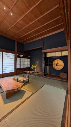 a room with a bed and a clock on the wall at 古民家ラグジュアリーホテル 金井西洋館 in Sado