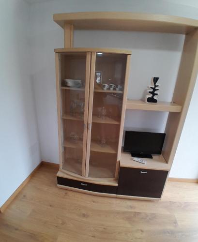 a wooden book shelf with a tv in a room at T1TR Anciao in Ancião