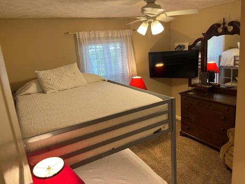 a bedroom with a bed and a mirror and a television at Classic City 3 bedroom 2 bath condo with deck close to UGA, Five Points, and Memorial Park in Athens in Athens