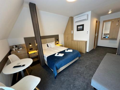 a hotel room with a bed and a table and chairs at Villa Nautica in Łeba