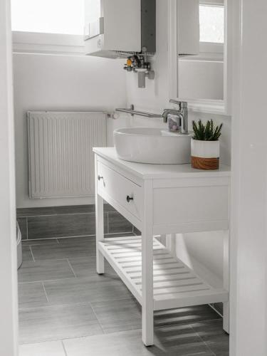 a white bathroom with a sink and a mirror at Ferienhäuser Insel Usedom Haus Milo 5 - Blick aufs Achterwasser! Whirlpool und Sauna in Lütow