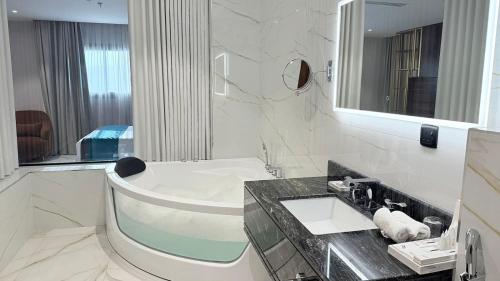 a white bathroom with a sink and a mirror at فندق رويال دايموند إحدى فنادق مجموعة لوريف By Le Reve Company in Taif
