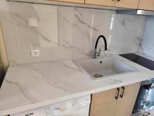 a kitchen with a sink and marble counter top at GEOMELOS Georgios APARTMENTS CHIOS in Chios