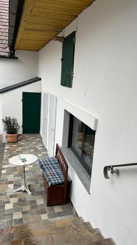 a patio with a table and a bench next to a building at Haus Crisan- Garconniere in Gasthof