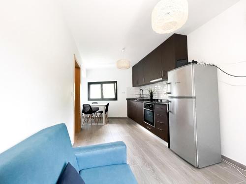 eine Küche mit einem blauen Sofa und einem Kühlschrank in der Unterkunft Royal House AL in Rio Caldo