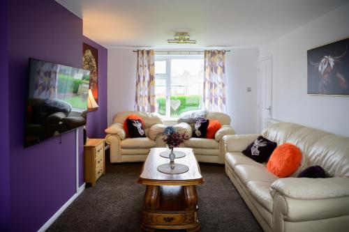 a living room with two couches and a table at Strelley house 4 , Perfect for business trip & Families holiday or working proffesionals-5 min from M1 J25 , 500MB Wi-Fi , Netflix , Fully equiped kitchen , Asda supermarket 5 min walk , Free Secure parking with CCTV ,available monthly deals in Nottingham