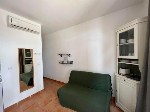 a room with a green chair and a mirror at Le Domaine de la mer - Appartements de plage dans un cadre enchanteur in Hyères