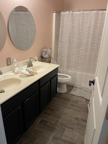a bathroom with a sink and a toilet and a mirror at Family Friendly House in Port Saint Lucie