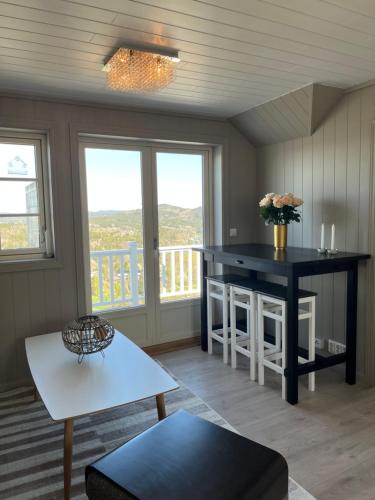 Una sala de estar con una mesa y un balcón. en Sjåen Panorama, en Kragerø
