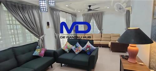 a living room with a couch and a no sign on the wall at Grey Fantasy Homes#Sunway Water Theme Park in Ipoh