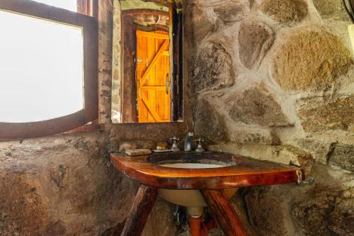 a stone bathroom with a wooden sink and a window at Habitaciones individuales o Dobles en La Llave in San Javier
