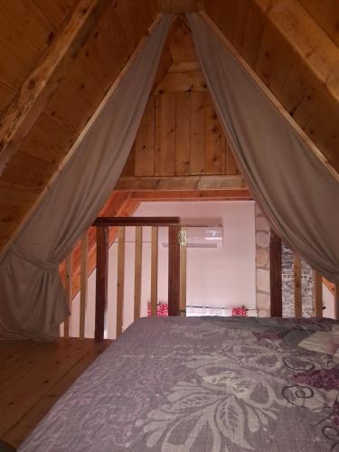 a bedroom with a bed in a wooden attic at Vikendica Gradačka Poljana in Šavnik