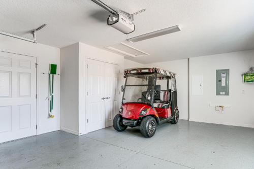 a small red golf cart parked in a room at Village of Collier Retreat with Golf Cart and Lanai! in The Villages