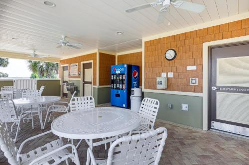 a restaurant with tables and white chairs and a soda machine at Village of Collier Retreat with Golf Cart and Lanai! in The Villages