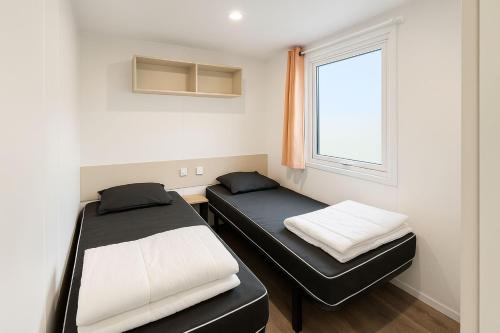 une chambre avec deux lits et une fenêtre dans l'établissement Trois-lets - Evasion et Confort au Bois Masson, à Saint-Jean-de-Monts