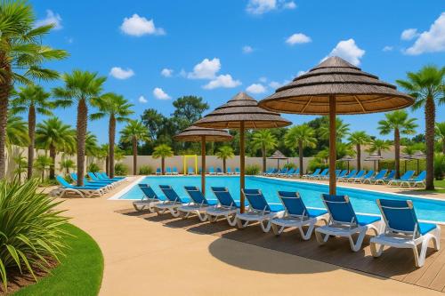 une piscine avec chaises, parasols et palmiers dans l'établissement Trois-lets - Evasion et Confort au Bois Masson, à Saint-Jean-de-Monts