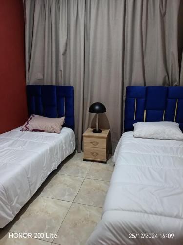 two beds sitting next to each other in a room at Appartement bouskoura 2 chambres near aeroport in Bouskoura