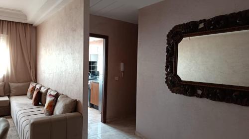 a living room with a couch and a mirror on the wall at Appartement bouskoura 2 chambres near aeroport in Bouskoura