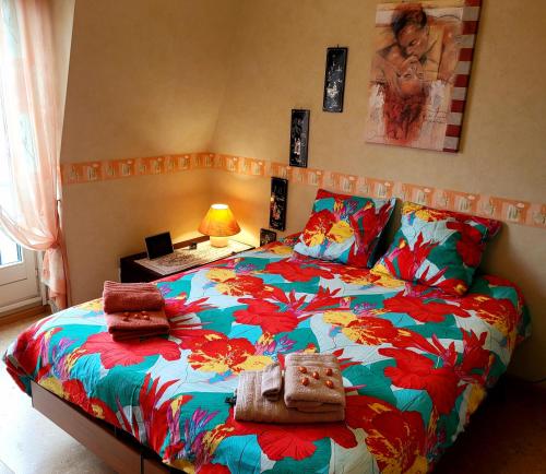 - une chambre avec un grand lit et une couette colorée dans l'établissement L' Appart BELLE VUE GARE ET CENTRE 10 mn à pied GARAGE GRATUIT, à Colmar