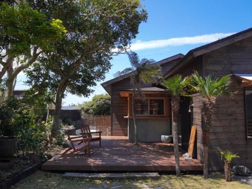 a house with a porch with a bench and trees at suo Camellia Island Inn - Vacation STAY 95452v in Oshima