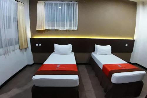 two beds in a small room with two beds sidx sidx sidx at Hotel Bumi Makmur Indah in Bandung