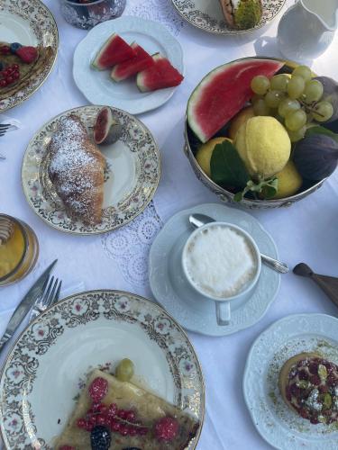 a table with plates of food and bowls of fruit at B&B La Villa in Giardini Naxos