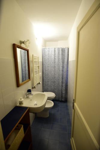 Un baño con dos inodoros, un lavabo y un espejo. en La Casa Sulla Mattonata accogliente appartamento sulla tipica creuza genovese con bella vista e a due passi dalla Stazione Principe, en Génova