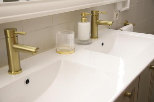a bathroom sink with two faucets and a glass at MD Chalet con piscina Mareny Beach in Mareny Blau
