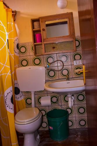 a small bathroom with a toilet and a sink at Maison d'Accueil - Fondation San Filippo Neri in Bujumbura