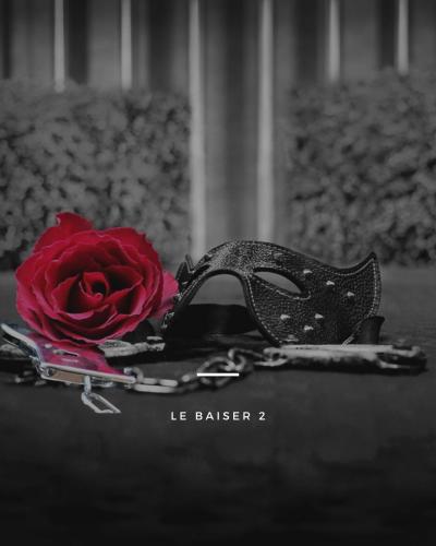 a red rose and a black mask on a table at Le baiser 2 Love room du plaisir interdit in Saint-Arnoult