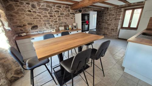 une cuisine avec une table et des chaises en bois dans l'établissement Le Cottage de Jousseaume, à Mortagne-sur-Sèvre