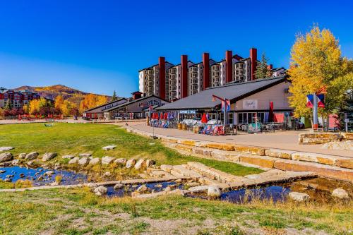 a building with a river in front of it at Torian Plum Creekside 418 in Steamboat Springs