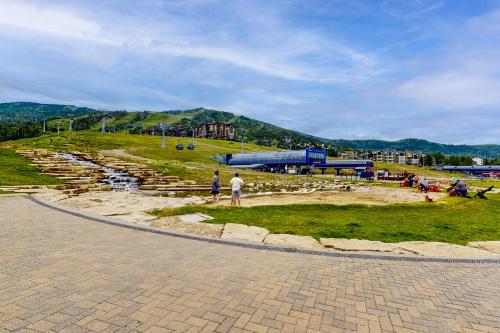 a group of people standing on a grassy hill at Torian Plum Creekside 418 in Steamboat Springs