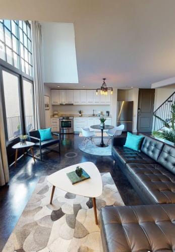 a living room with a couch and a table at Heart of Cloverdale Loft - Free Gated Parking in Montgomery