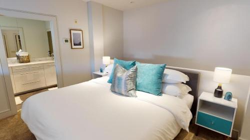 a bedroom with a large white bed with blue pillows at Heart of Cloverdale Loft - Free Gated Parking in Montgomery