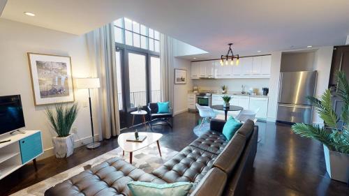 a living room with a couch and a kitchen at Heart of Cloverdale Loft - Free Gated Parking in Montgomery