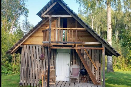 a tree house with a porch and two chairs on a deck at Oravapesa B & B & saun in Kose