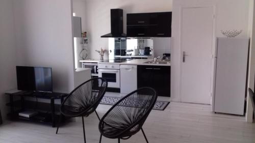 Il comprend une cuisine avec deux chaises et un réfrigérateur. dans l'établissement 3p Cannes proximité croisette, à Cannes