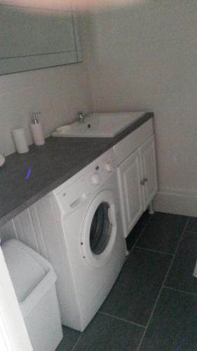 - un lave-linge blanc dans la salle de bains pourvue d'un lavabo dans l'établissement 3p Cannes proximité croisette, à Cannes