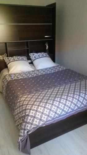 - un lit avec une tête de lit en bois et 2 oreillers dans l'établissement 3p Cannes proximité croisette, à Cannes