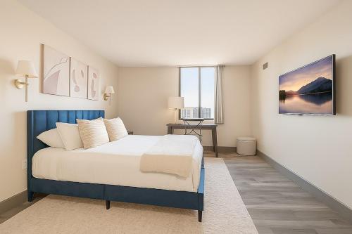 a bedroom with a blue and white bed and a desk at Modern Condo DWNTN Hartord XL Center GYM in Hartford