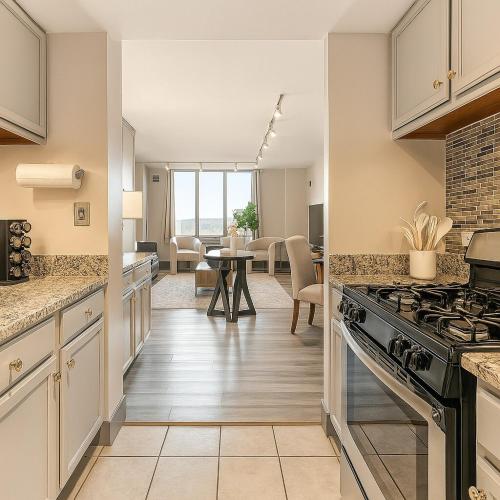 a kitchen with a stove and a dining room at Modern Condo DWNTN Hartord XL Center GYM in Hartford