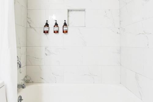a white bathroom with three bottles of beer at Modern Condo DWNTN Hartord XL Center GYM in Hartford