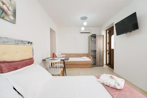 a room with two beds and a table with a television at Klaudia's House in Panayia