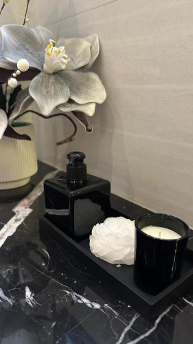 a black tray with a cup of coffee and a flower at Villa 22 in Ajman 