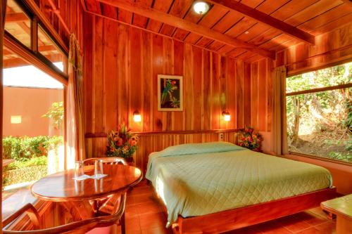 蒙特韋爾德哥斯達黎加的住宿－翠柏酒店，一间卧室配有一张床和一张桌子