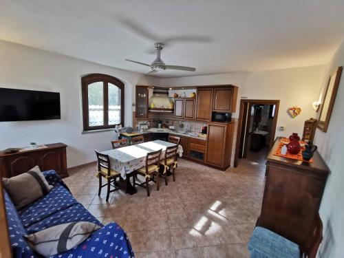 a living room with a dining table and a kitchen at Le Frasche di Marido holiday apartments in Alberese