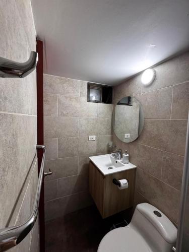 a small bathroom with a toilet and a sink at Apartamento en Pereira - Pinares in Pereira